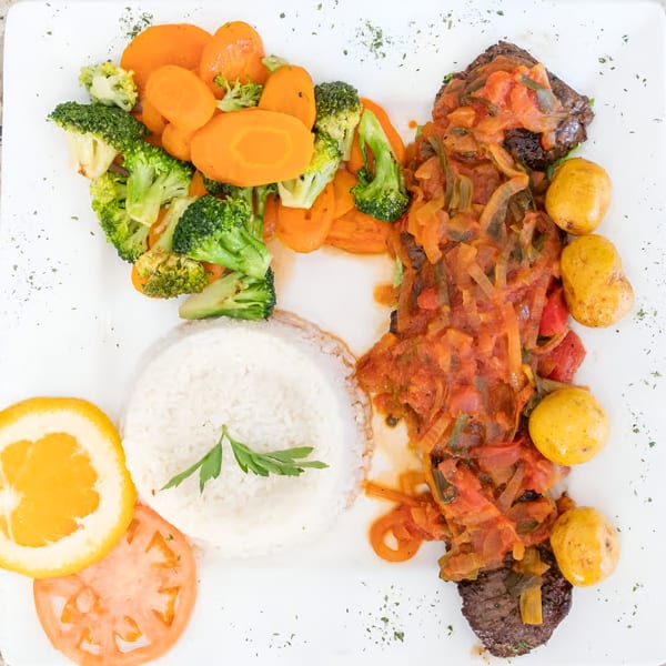 Makondo Restaurant's Colombian dish with steak, rice, vegetables, and potatoes on a white plate.