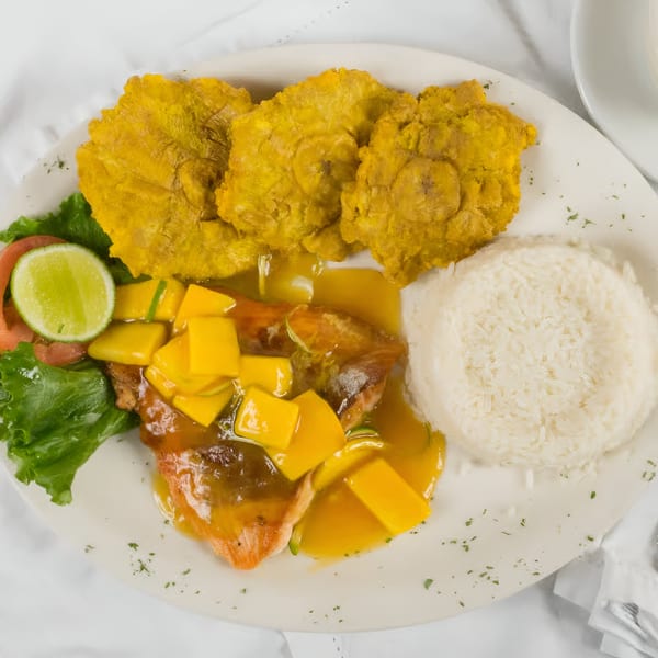 Makondo Restaurant's Colombian dish with fish in mango sauce, rice, tostones, and a lime wedge.