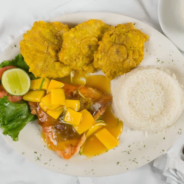 Makondo Restaurant's Colombian dish with fish in mango sauce, rice, fried plantains, and a lime.
