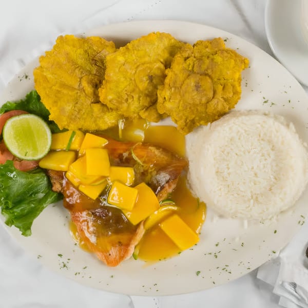Makondo Restaurant's Colombian dish with fish in mango sauce, rice, tostones, and a side salad.